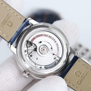 BLS Omega De Ville Collection     Original Mold Master Chronometer This timepiece is crafted from stainless steel, featuring a domed dial treated with deep blue PVD coating. Its surface bears irregular vertical textures, creating a sunray-brushed finish. Particularly striking are the rhodium-plated hands, alternating with Roman numeral hour markers and cabochon-set hour indices.A date window is positioned at the 6 o'clock mark, while the dial is adorned with a "railway track" minute scale, complementing the watch's minimalist aesthetic. It is fitted with a stainless steel bracelet. Clasp type: butterfly clasp. Powered by the Omega 8800 Master Chronometer movement with a black balance wheel, the movement's elegant operation is clearly visible through the scratch-resistant sapphire crystal caseback.